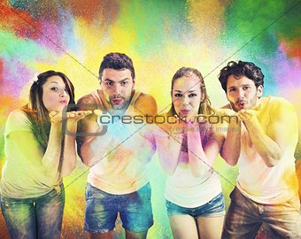 Friends blowing colored powders