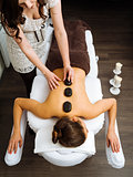 Massage therapist applying a hot stone massage
