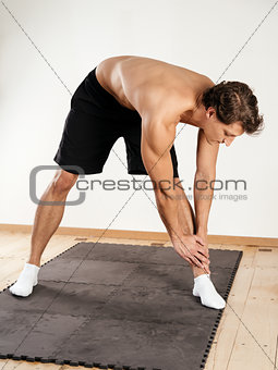 Young man doing standing leg stretches