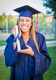 Expressive Young Woman Holding Diploma in Cap and Gown