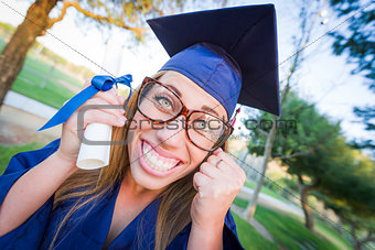 Expressive Young Woman Holding Diploma in Cap and Gown