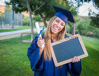 Woman Holding Diploma and Blank Chalkboard Wearing Cap and Gown