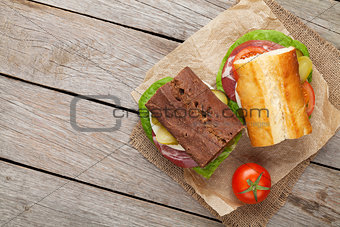 Two sandwiches with salad, ham, cheese and tomatoes