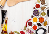 Various spices and condiments on white wooden background