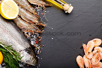 Fresh raw sea food with spices on black stone