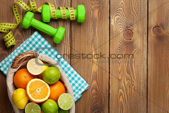 Citrus fruits in basket and dumbells. Oranges, limes and lemons