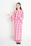 Asian girl in pink batik dress showing somethings