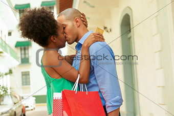 African American Couple Shopping With Credit Card Kissing