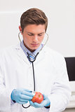 Scientist listening apple with stethoscope
