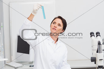 Scientist looking attentively at test tube