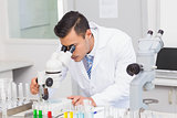 Serious scientist using microscope