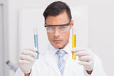 Scientist examining precipitates in tubes