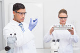 Scientists looking at petri dish and tubes