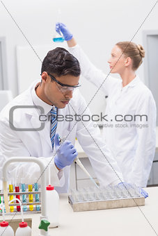 Scientists examining tubes and baker