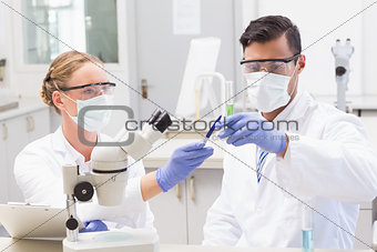 Concentrated scientists looking at beaker