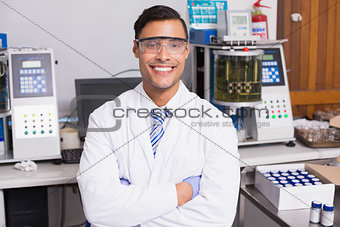 Happy scientist smiling at camera with arms crossed