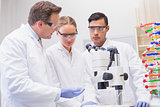 Scientists working attentively with microscope
