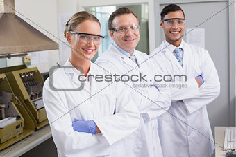 Smiling scientists looking at camera arms crossed