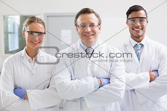 Smiling scientists looking at camera arms crossed