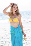 Smiling pretty blonde in bikini holding a starfish