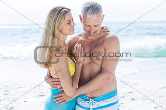 Happy couple standing by the sea and hugging each other