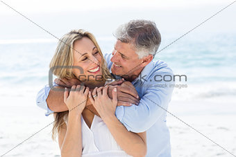Happy couple hugging each other by the sea