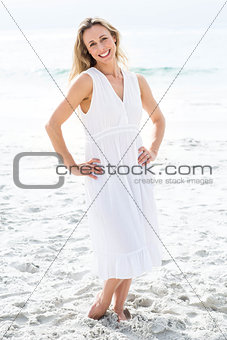 Smiling blonde in white dress looking at camera