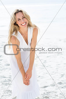 Smiling blonde in white dress looking at camera