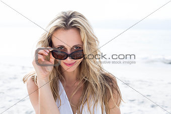 Smiling blonde in white dress wearing sun glasses