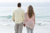 Happy couple standing by the sea and holding hands