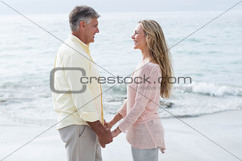 Happy couple holding hands and smiling at each other