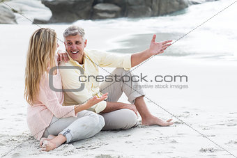 Happy couple sitting on the sand