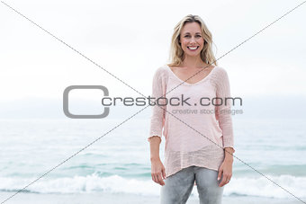 Smiling pretty blonde standing by the sea