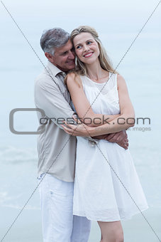 Happy couple standing by the sea and hugging each other
