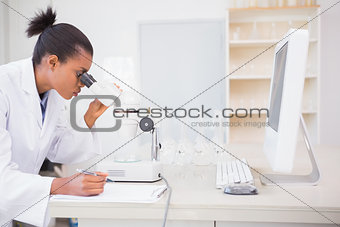 Concentrated scientist looking in microscope