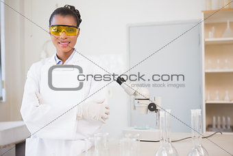 Smiling scientist looking at camera and holding clipboard