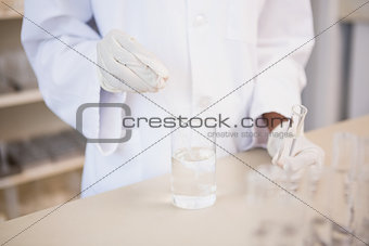 Scientist examining test tube and beaker