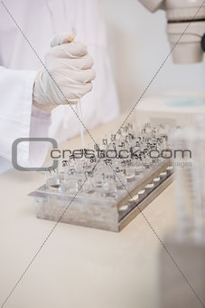 Scientist working with many test tubes and pipette