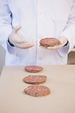 Scientist examining beefsteaks in petri dish