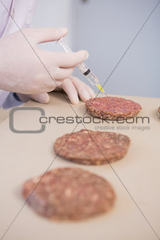 Scientist injecting beefsteaks