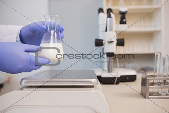 Scientific weighing white liquid in beaker