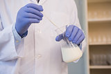 Scientist examining white liquid