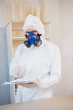 Scientist in protective suit pointing clipboard