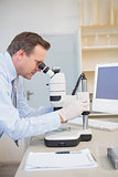 Scientist using computer and microscope