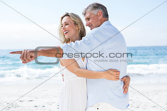 Happy couple hugging each other and pointing something