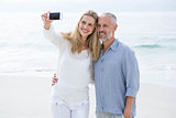 Happy couple taking selfie with mobile phone