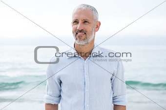Smiling man standing by the sea
