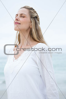 Smiling pretty blonde standing by the sea