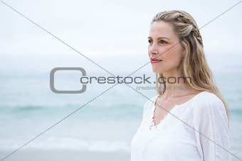 Smiling blonde standing by the sea