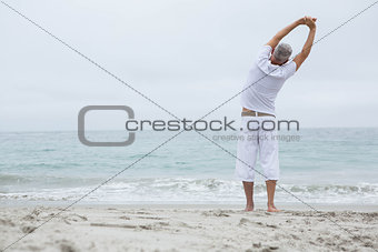 Man stretching his arms by the sea